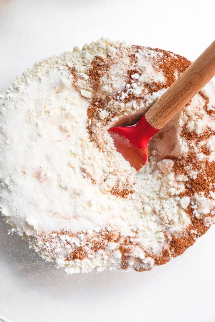 mixing the dry ingredients in a bowl with a red spatula