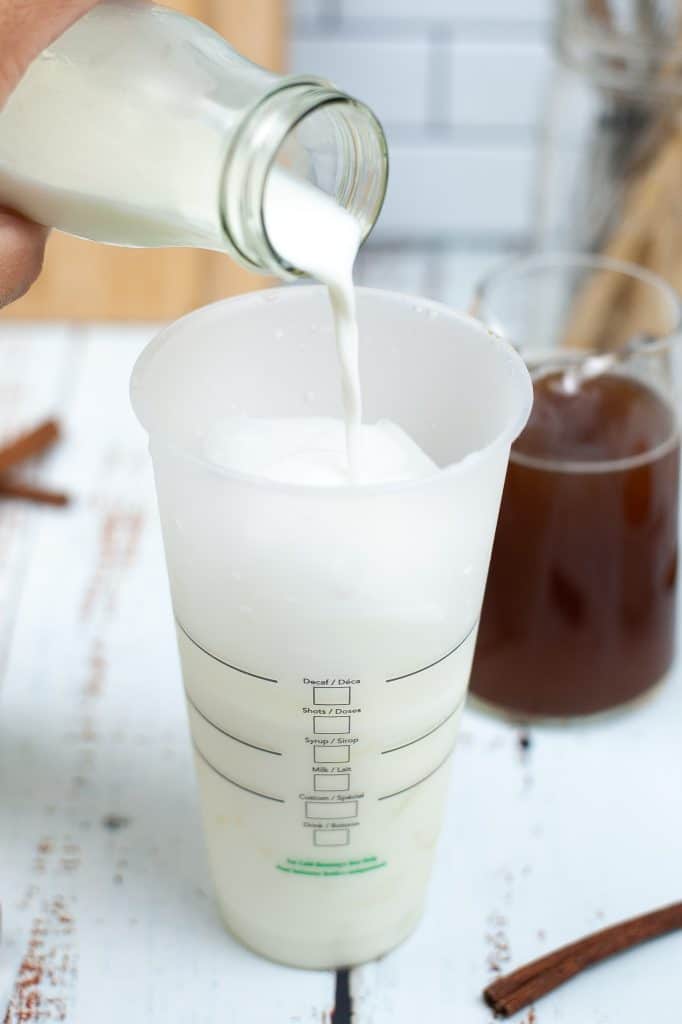 pouring milk into a starbucks cup