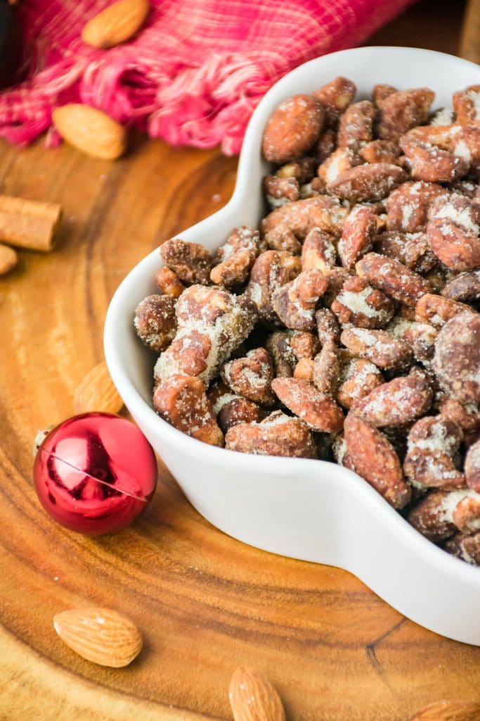 candied nuts in a serving bowl on a cutting board
