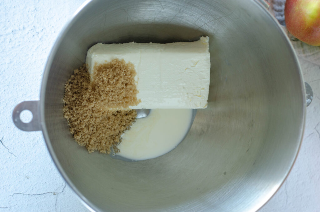 overhead of softened cream cheese and brown sugar in mixing bowl