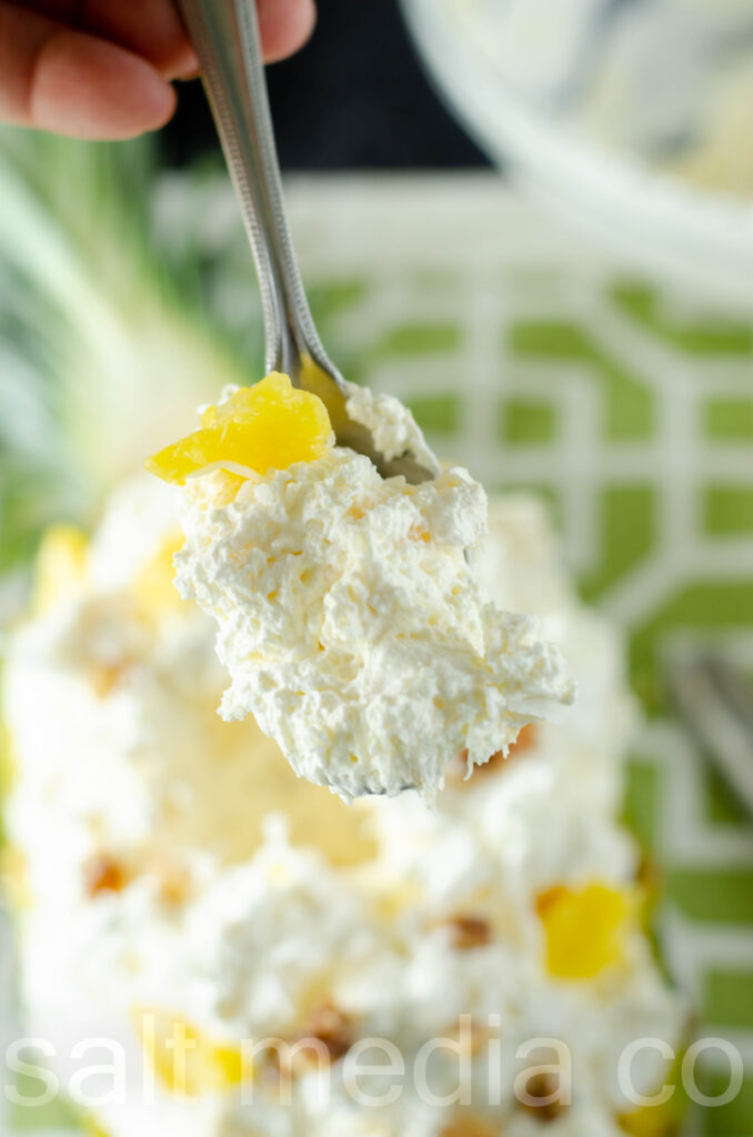 spoon full of pineapple fluff salad overhead shot on green napkin