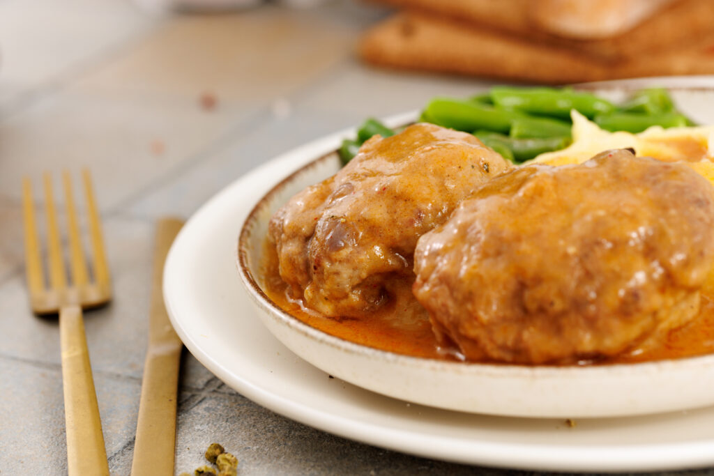 close up of salisbury steak on plates